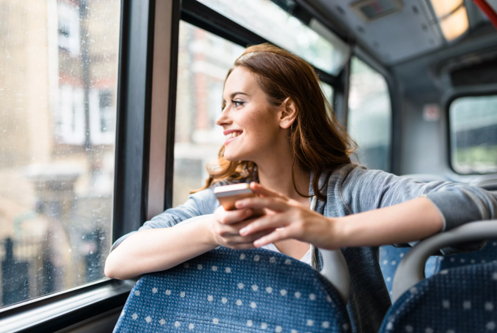 mulher feliz viajando de ônibus na cidade